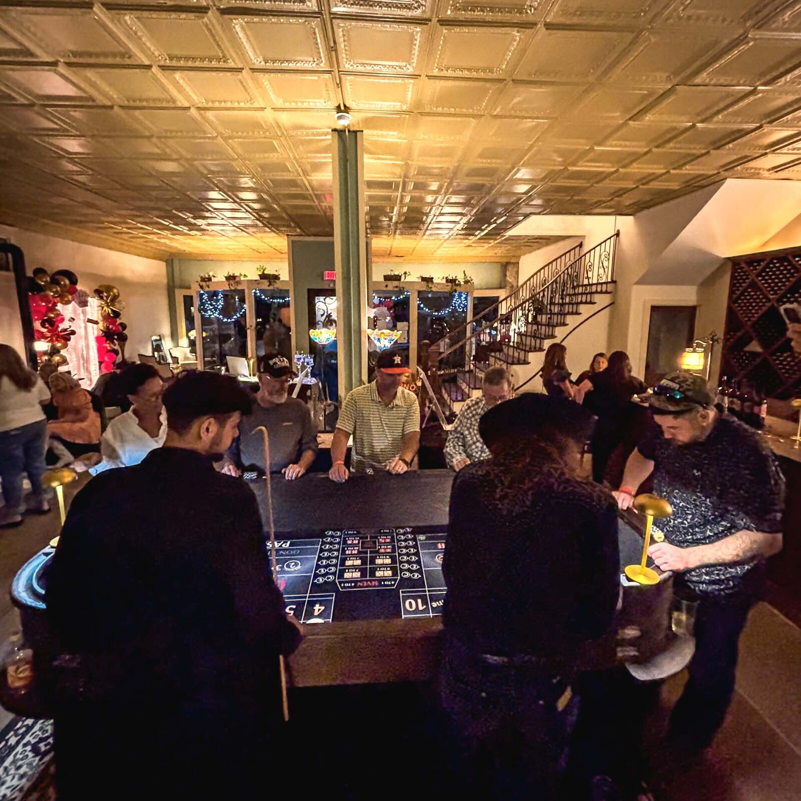 Guests gathered around a craps table at Casino Night in the Pineywoods Vineyard venue